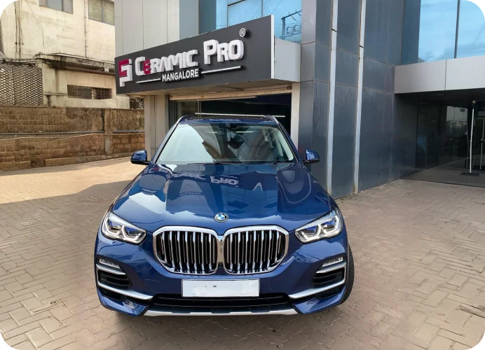 Blue BMW SUV parked outside the Ceramic Pro store